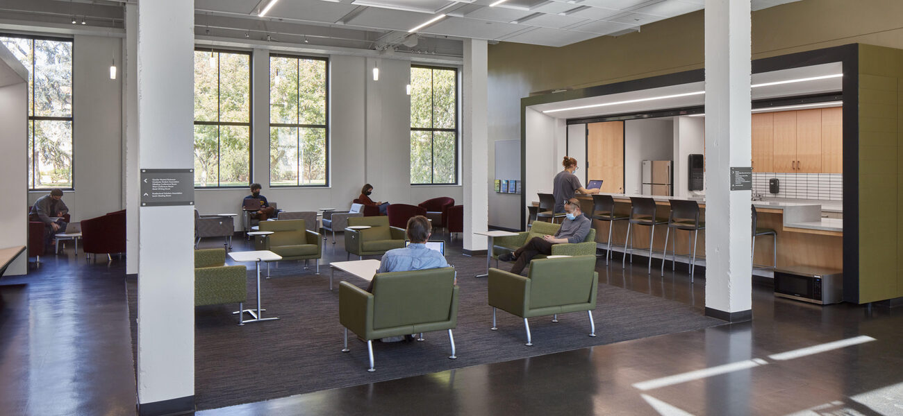 Students sit in a lounge and at a food counter. 