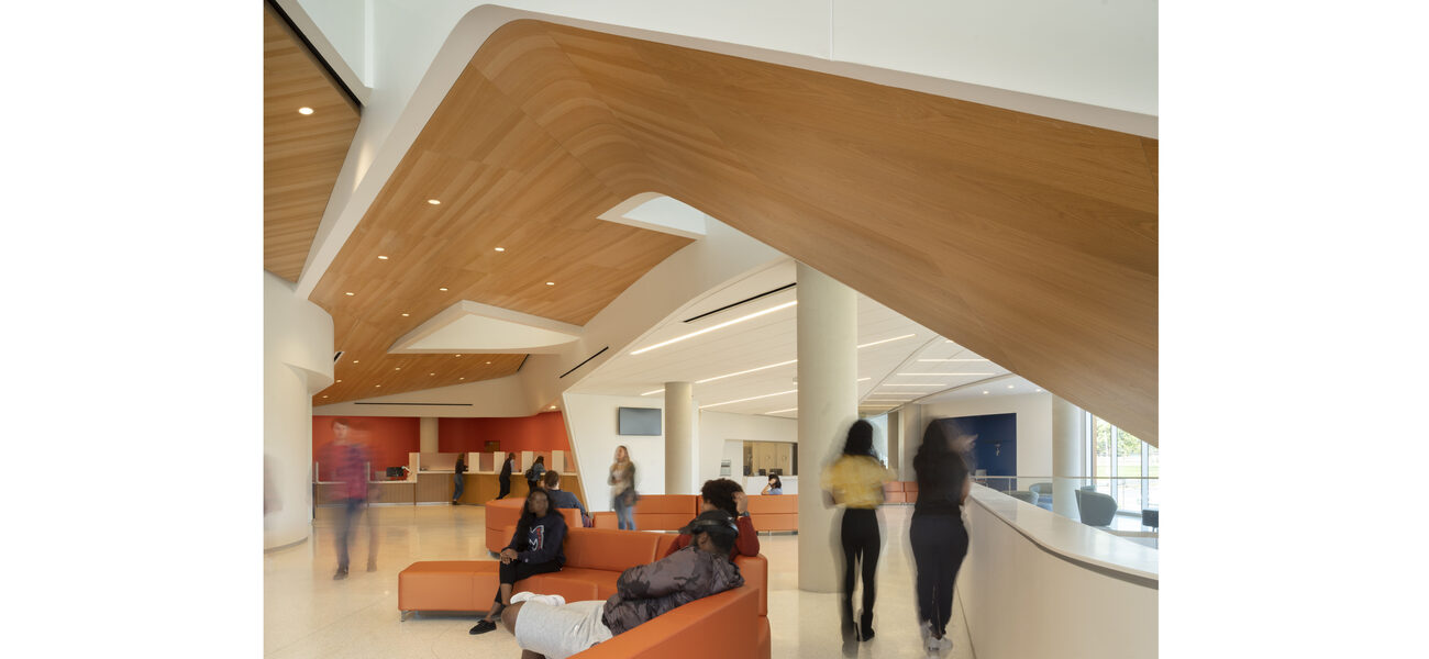 Students sit on couches under a vaulted ceiling.