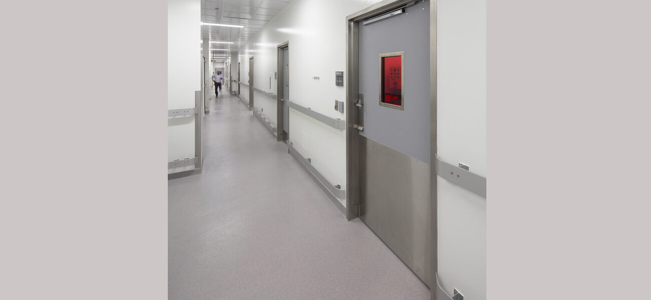 Corridor with a man at the end and closed doors on the right