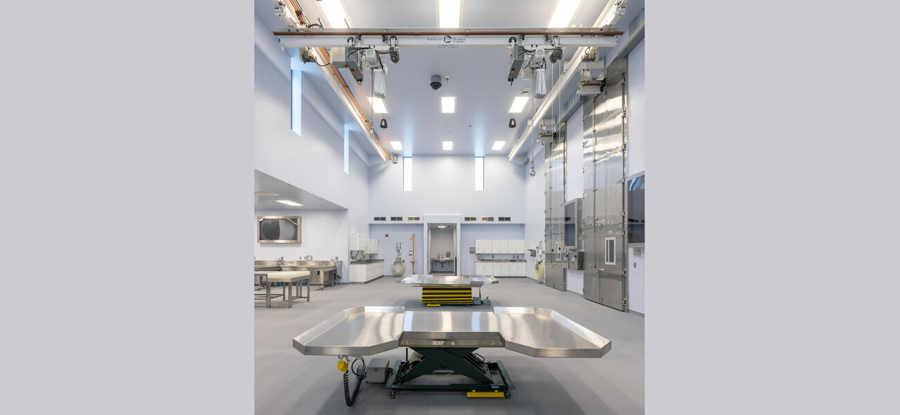 A lab with large dssection tables and a crane system on the ceiling to lift carcasses