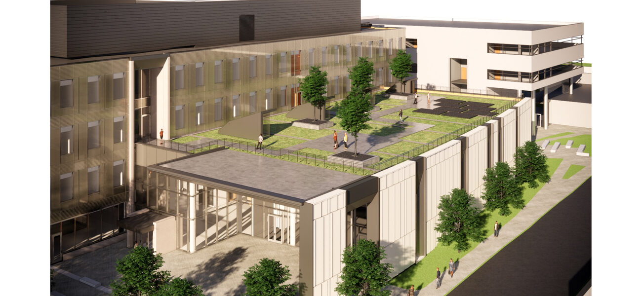 Trees and grass grow on a flat roof of a four-story building.