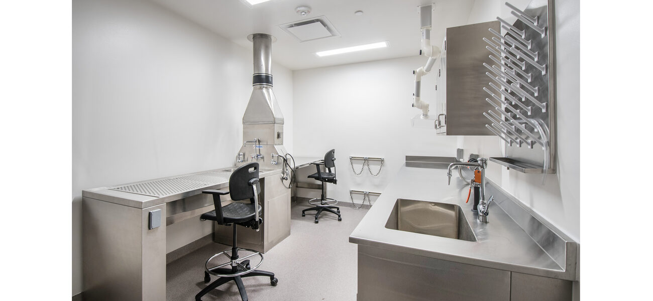 Stainless steel benches line the walls of an empty lab.