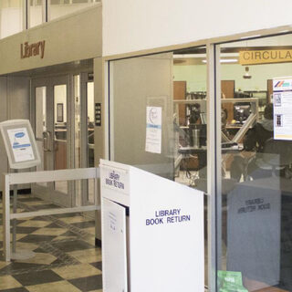 A glass wall and a locked door secure the entrance to the library